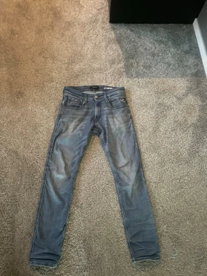 Blå slim fit jeans från Replay - Säljer ett par blå slim fit jeans från Replay med klassisk femficksdesign. Jeansen har dragkedjegylf och tydliga sömmar på bakfickorna. Perfekta för en avslappnad och trendig look.STORLEK PÅ BILD 3