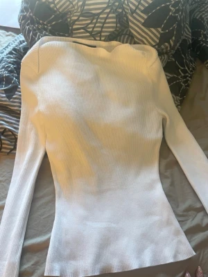 Vit ribbad tröja från Bik Bok - Säljer en vit, långärmad ribbad tröja från Bik Bok. Tröjan har en figurnära passform och är tillverkad i ett stretchigt material som sitter snyggt på kroppen. Perfekt att styla med jeans eller kjol för en clean look.