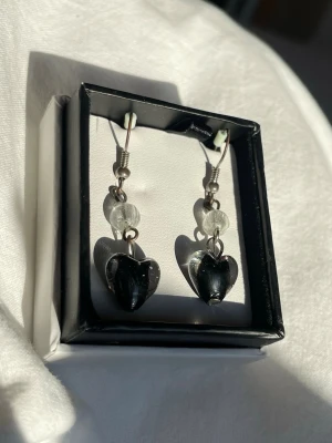 Svarta hjärtörhängen med pärldetalj - Snygga vintage örhängen med detaljer i glas och krokar i metall. Har tecken på användning men är annars i gott skick!