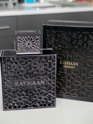 Rayhaan Obsidian - Rayhaan Obsidian parfym i en elegant svart flaska med geometriskt mönster och matchande lock. Flaskan har en lyxig och modern design med detaljer i metall och tydlig logotyp på framsidan. Kommer i en snygg svart förpackning med gulddetaljer.
