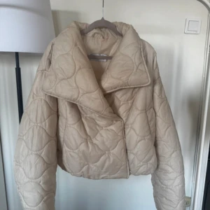 Beige quiltad pufferjacka från ASOS - Skitsnygg pufferjacka från asos design, lite croppad. Passar jätte bra nu till hösten och vinterns lite varmare dagar❤️💕 Lite smink på insidan men sol inte syns när den är knäppt 