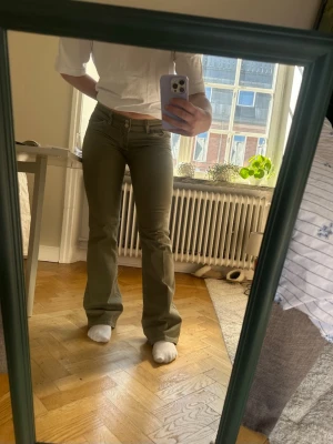 Gröna lågmidjade jeans - Gröna lågmidjade jeans från Nelly i storlek 38. Endast använda ett fåtal gånger så i mycket bra skick! 