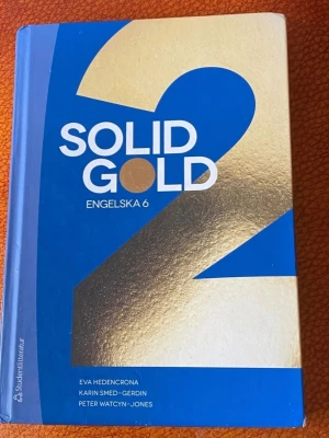 Solid Gold 2 Engelska 6 kursbok - Solid Gold 2 Engelska 6 är en kursbok med blått och guldigt omslag. Boken är skriven av Eva Hedencrona, Karin Smed-Gerdin och Peter Watcyn-Jones. Perfekt för gymnasiekurser i engelska och har hårda pärmar.