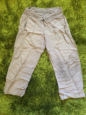 Sandwich Beige Baggy Linnebyxor - Säljer ett par beige linnebyxor med baggy fit och bred midjeresår som är justerbar och funkar bra som lowrise . Det finns två sidofickor och de är tillverkade i ett mjukt, tunt material som är väldigt bekvämt. Passar någon som är runt 160-165cm lång.