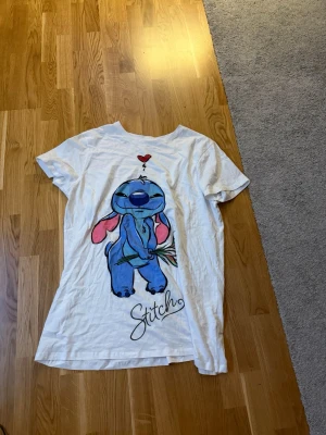 Vit Stitch t-shirt med tryck - Gullig T-shirt med tryck av Stitch! Använd väldigt fåtal gånger, och från Primark i Berlin. 