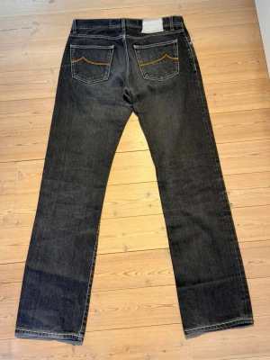 Svarta raka jeans från Jacob Choën  - Säljer ett par svarta jeans från Jacob Choën med raka ben och klassisk femficksmodell. Jeansen har kontrastsömmar på bakfickorna och är tillverkade i slitstark denim. Perfekta för en avslappnad och stilren look. P3
