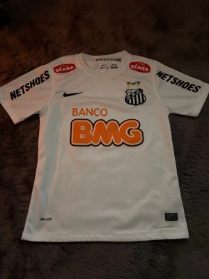 Santos neymar tröja - Säljer en vit Santos FC matchtröja från Nike med Neymar Jr och nummer 11 på ryggen. Jag säljer den för att den inte kommer till andvändning men det är en bra kvalitet tröja med många minnen från neymar och om du har frågor är det bara att kontakta