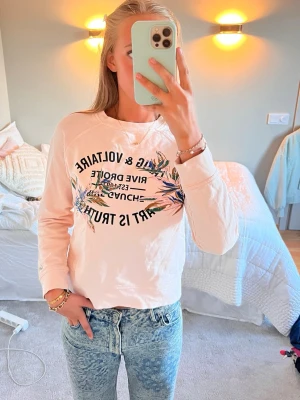 Ljusrosa sweatshirt Zadig & Voltaire - Ljusrosa sweatshirt från Zadig & Voltaire med tryck framtill i svart text och färgglada blommor. Tröjan har rund halsringning och långa ärmar. Perfekt till jeans för en avslappnad och trendig look. Ny pris 1100 säljs för 900