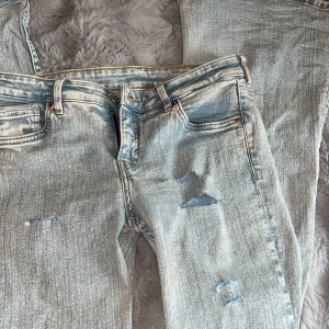 ljusblå slitna låga jeans - säljer dessa jeans som jag själv gjort hålen på, de är lågmidjade och bootcut/flare