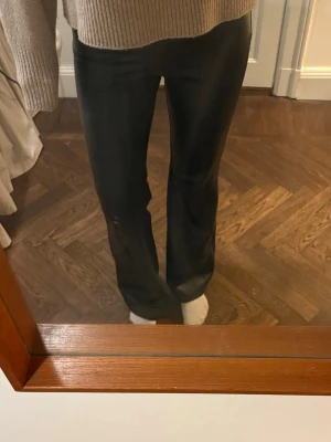 Boutcut byxor i skinnimitaion - Säljer ett bar byxor i fakeskinn. Byxorna sitter tajt längs benen och boutcut nedtill. Hör av er vid frågor/fler bilder osv.🩷