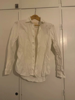 Vit skjorta från A Day's March - Vit manchesterskjorta från A Day's March i bomull. Skjortan har lång ärm, krage och knappar framtill. Perfekt basplagg med clean look och normal passform.