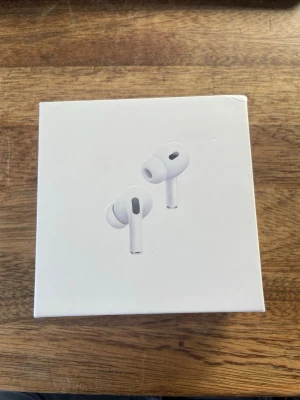 Apple AirPods Pro trådlösa hörlurar - Säljer ett par vita Apple AirPods Pro med laddningsetui. Hörlurarna är in-ear och har en stilren, minimalistisk design i plast. Perfekta för dig som vill ha grymt ljud och smidig anslutning till din iPhone eller andra Apple-enheter.