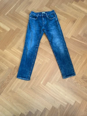 Snygga blåa jeans - Säljer ett par klassiska blå jeans med raka ben och snygga detaljer.🧊👌 Jeansen har dragkedja , bälteshällor och en cool tvättad look.😎Perfekta för en avslappnad stil och passar till det mesta i garderoben. Kan kläs upp men också ner och passar många storlekar!🙌🔥Tveka inte att höra av dig!
