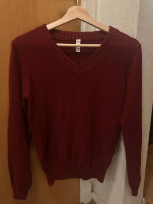Vinröd stickad V-ringad tröja - Stickad tröja med V-ringning och långa ärmar, vindröd i storlek xs typ