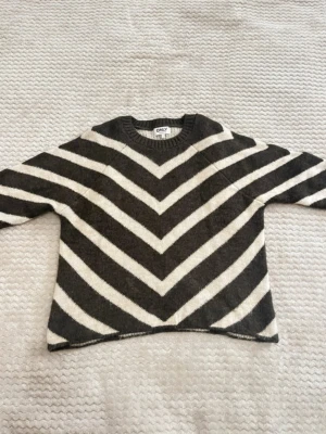 Stickad tröja - Mysig stickad tröja från ONLY i brun och vitt med breda ränder. Tröjan har rund halsringning.