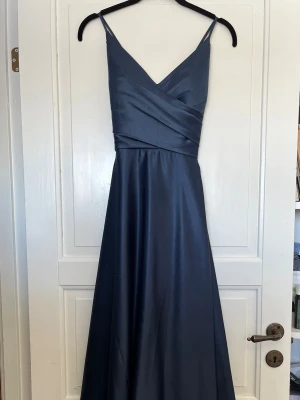 Balklänning - Jättefin mörkblå balklänning i bra skick, använd 1gång. Storlek 38, passar på mig som är knappt 170 lång. Den knyts i ryggen och är där med justerbar. Skriv för fler bilder!