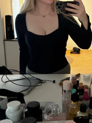 Mörkblå långärmad topp med fyrkantig ringning - Snygg mörkblå långärmad topp med fyrkantig ringning och figurnära passform. Storlek M från Gina Tricot