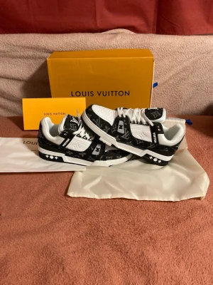 Lv trainer  - Snygga L sneakers i svart och vitt med klassiskt LV-monogram över hela skon. Lågt skaft, vita skosnören och detaljer i både läder och textil. Perfekt för dig som vill sticka ut med ex.
