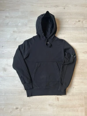 Svart CP Company Hoodie Storlek S - Fin Cp Company Hoodie i svart färg. Tröjan är i mycket bra skick och sparsamt använd. |  Äkta som allt annat jag säljer!✅|  Storlek: S | Skick: Mycket Bra Skick  | Färg: Svart | Märke: CP Company | Modell: hoodie  |  Hör gärna av dig vid frågor så svarar jag så fort jag kan! 😁|  
