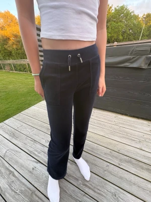 Mörk blåa juicy couture byxor - Säljer ett par mörk blåa juicy couture mjukisbyxor med bred resår i midjan och dragsko med metalländar. Byxorna har raka ben och stora fickor framtill. Perfekta för chill dagar och riktigt sköna att ha på sig. Materialet är mjukt och perfekta för mysiga sommarkvällar, modellen är 166 cm lång💕