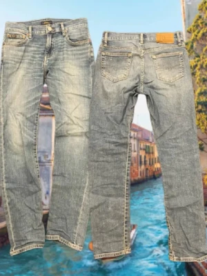 Ljusblå slim jeans från Ralph lauren - Säljer ett par ljusblå jeans från Ralph Lauren med klassisk femficksdesign och slim  ben. Jeansen har slitna detaljer och kontrastsömmar, samt en läderpatch bak i midjan. Perfekta för en avslappnad och trendig look.