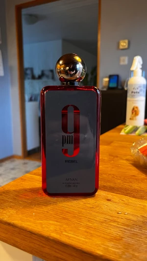 Afnan 9PM Rebel parfym 100ml - En modern och energisk doft med fruktiga och fräscha noter som möter varma träslag och mjuk vanilj. 9PM Rebel är ungdomlig, självsäker och har mycket bra hållbarhet, vilket gör den perfekt för både vardag och kvällar ute. En unik och uppmärksamhetsväckande doft som sticker ut från mängden.