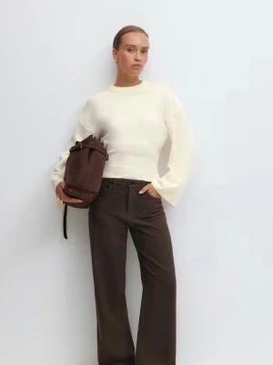 Vit stickad croppad tröja - Snygg vit stickad tröja med croppad passform och bred ribbad mudd i midjan. Tröjan har rund halsringning och vida ärmar, perfekt för en trendig och avslappnad look. Passar till både jeans och kostymbyxor. Toppen är vit  och använd ca 3 gånger, köptes för 400kr säljes för 250kr. Hör av dig vid frågor/ mer bilder ❤️