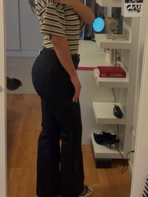 Svarta bootcut jeans med hög midja - Svarta jeans med bootcut-modell och hög midja. Jeansen har raka ben som blir vidare nedtill. 