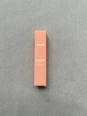 CAIA Brightening Eye Cream 15 ml - Brightening Eye Cream från CAIA i en snygg persikofärgad förpackning. Ögonkrämen kommer i en smal, rektangulär kartong och innehåller 15 ml. Perfekt för dig som vill pigga upp området under ögonen och få en fräschare look. Förpackningen är oöppnad och plomberad 