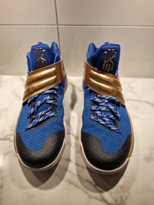 Unika Nike Kyrie 2 iD NYC Blue & Gold Storlek 42,5 - Unika Nike Kyrie 2 iD "NYC Blue & Gold" – Storlek 42,5 .Basketskor, Modellens styrka: Kyrie 2 är känd för sitt suveräna grepp, den rundade sulan och den stabila remmen över vristen. Det gör den till en mycket populär sko på planen. NYC / iD"skorna är specialdesignade via Nikes iD-program i färgerna blått och guld, vilket gör att köparen blir näst intill ensam om att äga just detta par. För 490:- extra så skickas Nike shoebag helt ny med även den är äkta, den brukar kosta 690:- annars.