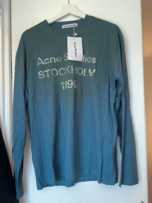 Acne studios long sleeve - Säljer en blå långärmad topp från Acne Studios med tryck 'Acne Studios STOCKHOLM 1996