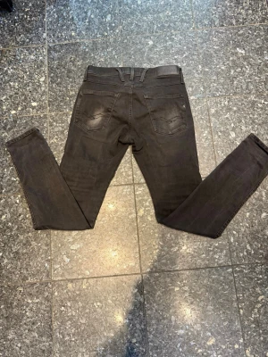 Svarta slim jeans från Replay - Säljer ett par svarta slim jeans från Replay med klassisk femficksdesign och slim passform. Jeansen har bälteshällor och är tillverkade i ett stretchigt material för extra komfort. Perfekta för dig som gillar en tight look.