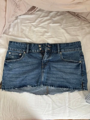 Blå jeanskjol med rå kant från 157 - Säljer en blå jeanskjol från 157, har klippt längst ner lite på kjolen och det är öppet på båda sidorna som man ser på bild 3.