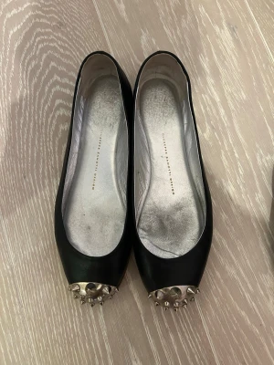 giuseppe zanotti ballerinaskor - supersöta giuseppe ballerinas med nitar som tyvärr är för stora för mig!! en extra sula o klack har lagts på undersidan så att dom håller längre så dom är i rätt bra skick. innersulan är 25cm men skulle säga att de känns större, står 38.5 på skon men de e mer 39.5. pris kan diskuteras!