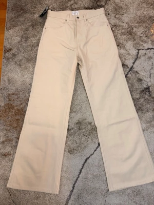 Peoples Fortune ecru bootcut - Snygga ecru selvedge jeans från nischad märke Peoples Fortune med låg midja och raka ben. Klassisk femficksmodell med bälteshällor och knappgylf. Tillverkade i ett kraftigare bomullstyg som ger en clean och stilren look.