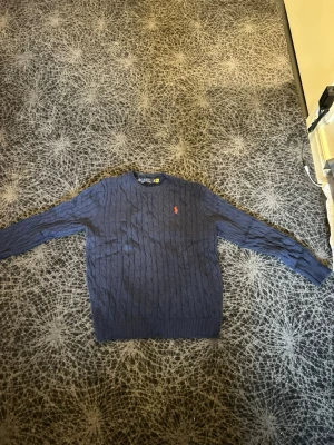 Mörkblå kabelstickad tröja Polo Ralph Lauren - Mörkblå kabelstickad tröja från Polo Ralph Lauren, pris kan diskuteras