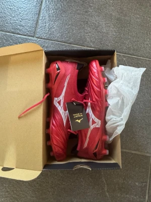 Röda Mizuno Morelia Neo fotbollsskor - Säljer ett par röda Mizuno Morelia Neo! Helt nya, prislappen är kvar, köpta för 3500kr