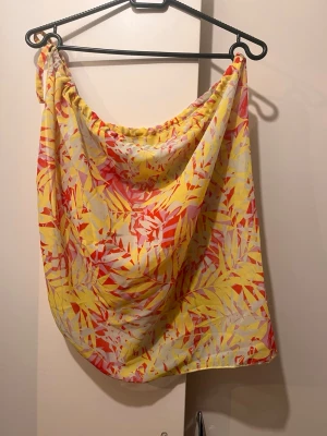 Ny strand kjol one size Hunkemöller  - Helt ny strand kjol / sarong i one size från Hunkemöller. Knytning i sidan, justerbar.  One size, justerbar i midjan.  Se alla bilder för mått. Längd: ca 50 cm på längsta.  Lite transparent tyg i färgerna beige gul rosa och röd. 