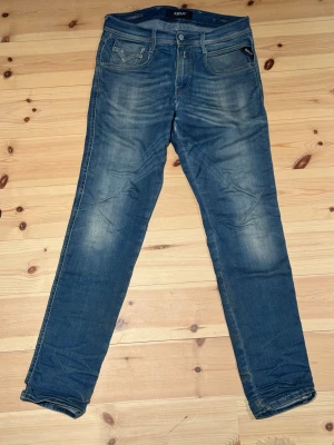 Replay Anbass Hyperflex - Säljer ett par blå jeans från Replay med smal passform. Modellen är Replay Anbass. Storlek: W27 L32. Slitningar som finns syns i bilderna. Hör gärna av dig vid frågor!
