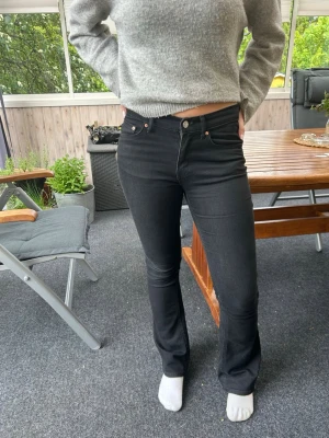 Svarta bootcut jeans - Snygga svarta jeans med bootcut-modell. Jeansen har klassisk femficksdesign och smal passform upptill som går ut i ett lätt utsvängda ben. Perfekta till en avslappnad eller trendig look.