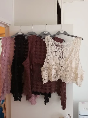 Spetsvästar från Zizzi i olika färger - Säljer flera snygga västar i spets med blommigt mönster. Från Zizzi. Finns i färgerna beige, svart, brun och lila. Perfekt att slänga över en topp för en bohemisk vibe. Västarna är ärmlösa och har vackra detaljer längs kanterna. M,L,XL