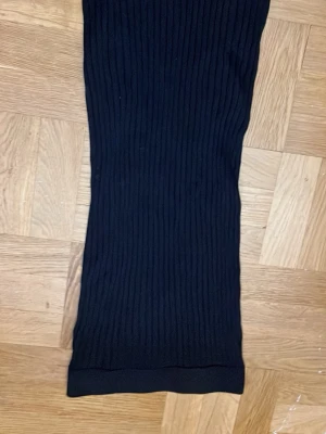 Svart ribbad långkjol från Lindex - Svart långkjol från Lindex i ribbat material. Kjolen har en enkel och stilren design med rak passform och elastisk midja. 