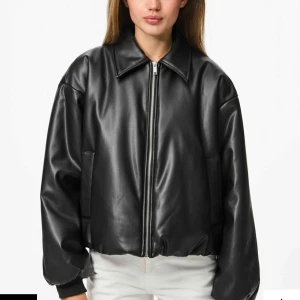 Svart oversized skinnjacka - Säljer en svart oversized skinnjacka med dragkedja framtill och bred krage. Jackan har en minimalistisk design med raka linjer och diskreta fickor på sidorna. Perfekt för dig som gillar en clean och modern look. Köpt för 749kr 💕