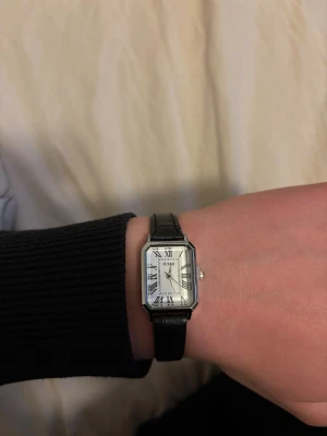 Cartier Tank klocka likande - En stilren Cartier liknande klocka med ett silver ur och ett svart läderarmband. Passar till alla outfits.