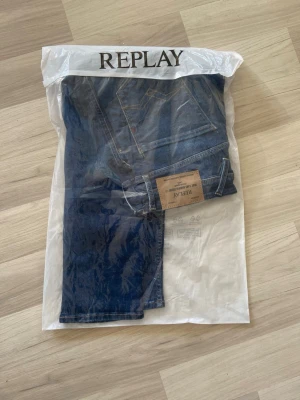 Blå jeans från Replay (slim fit) - Säljer ett par klassiska blå jeans från Replay med snygga kontrastsömmar och läderpatch bak i midjan. Jeansen har rak passform och är tillverkade i slitstark denim. Perfekta för dig som gillar tidlös och enkel stil.