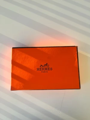 Svart bälte  - Svart bälte men ett H spänne i guld box med följare 115cm långt skriver om har några funderingar.