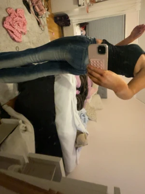 Kvarg jeans weekday - Säljer ett par blå bootcut jeans med snygga slitningar och ljusare partier på låren. Jeansen har klassisk femficksdesign och låg midja. Perfekta för dig som gillar en avslappnad och trendig look. 25/30 i längd 