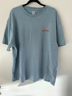 Blå T-shirt  - En blå pösig T-shirt med rött broderat ”BDG JEANS” tryck på bröstet. Står S men känns betydligt större i bredd, så rätt oversized men kortare i längd. Mjukt och nice material