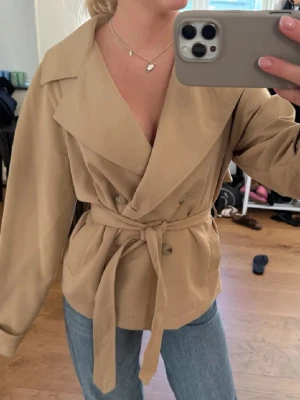 Beige Trenchcoat Strandivarius - Snygg beige trenchcoat från Strandivarius i XS, passar XS/S. Inte för kort i modellen🥰