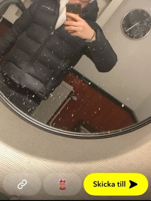 Svart pufferjacka från Sail racing  - Säljer en svart pufferjacka från Sail racing med huva och dragkedja framtill. Jackan har en klassisk boxig passform och diskret logga på bröstet. Perfekt för kalla dagar och riktigt skön att bära. Materialet är vadderat och håller värmen bra.